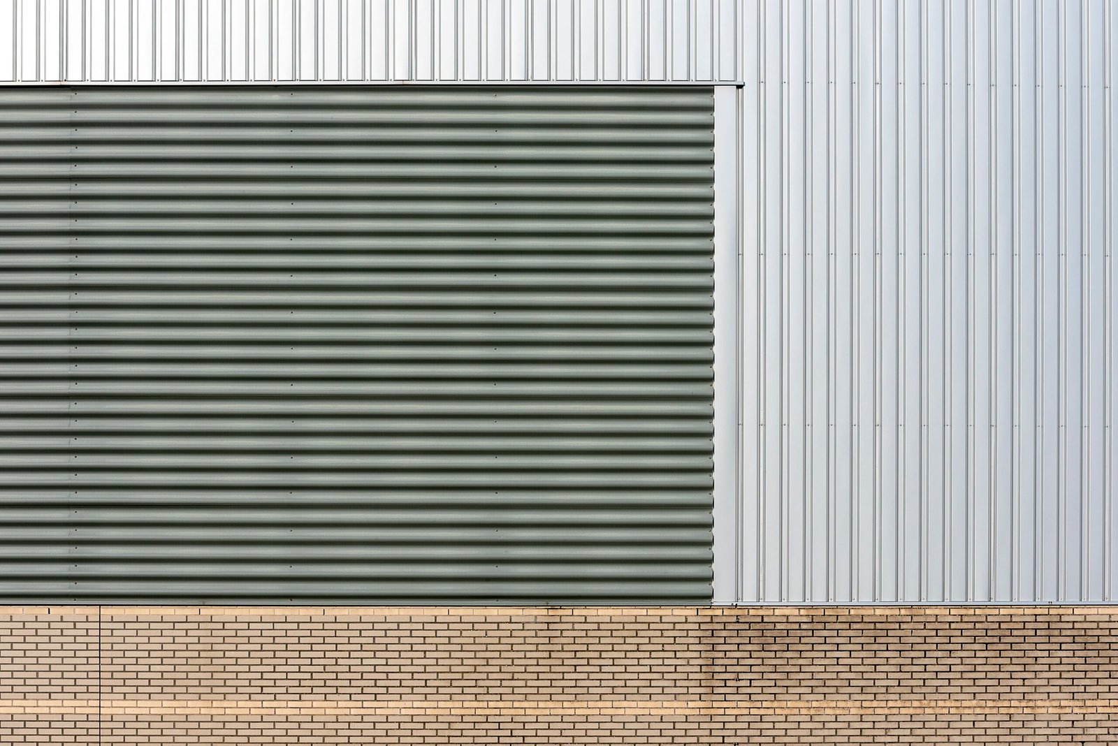 Fachada industrial con revestimiento metalico y base de ladrillo