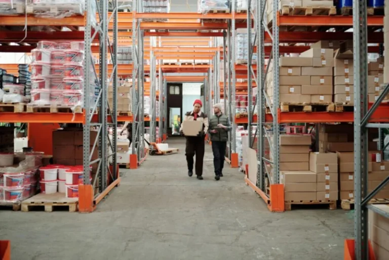 Trabajadores caminando en pasillo de bodega industrial