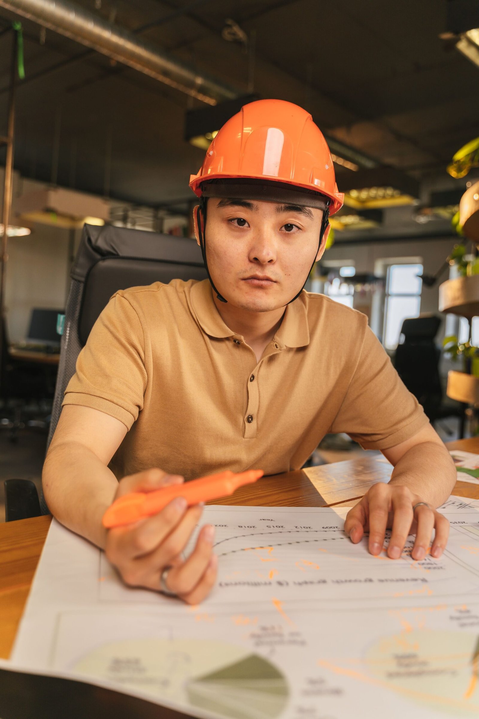 Arquitecto con casco de seguridad revisando planos