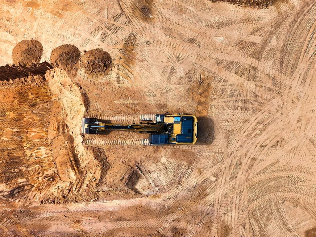 Vista aérea de una excavadora trabajando sobre el terreno de una obra