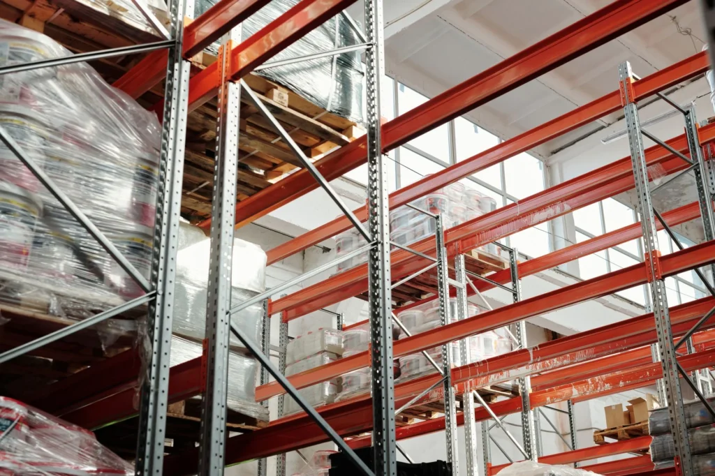 Racks de almacenamiento con tarimas de producto apiladas en varios niveles hacia el techo
