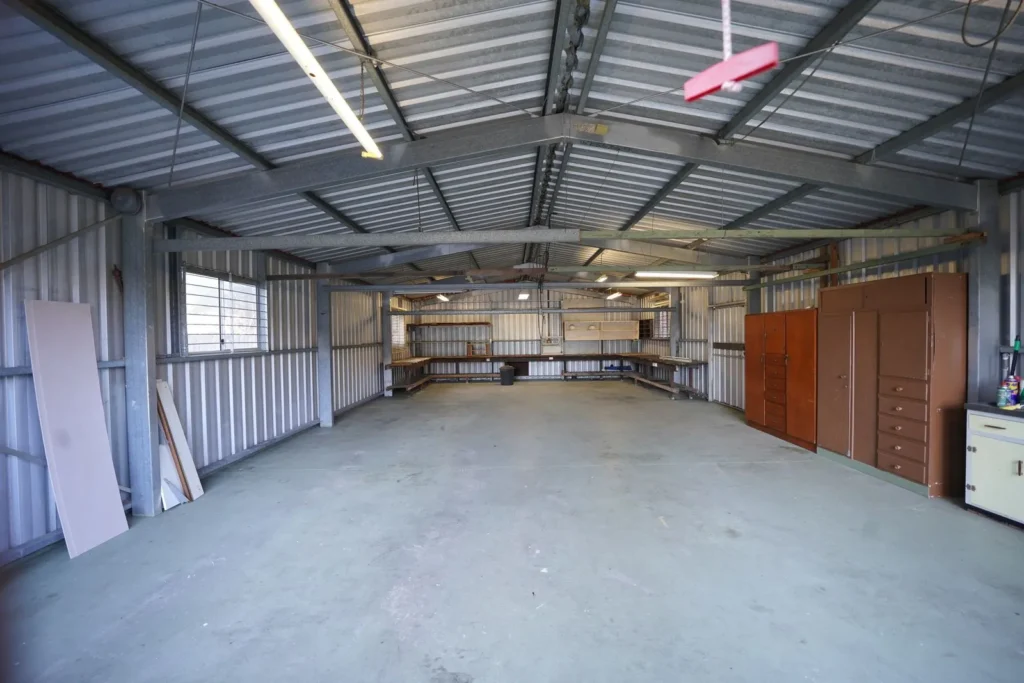 Interior de una bodega pequeña con muros y techo de lámina y piso de concreto