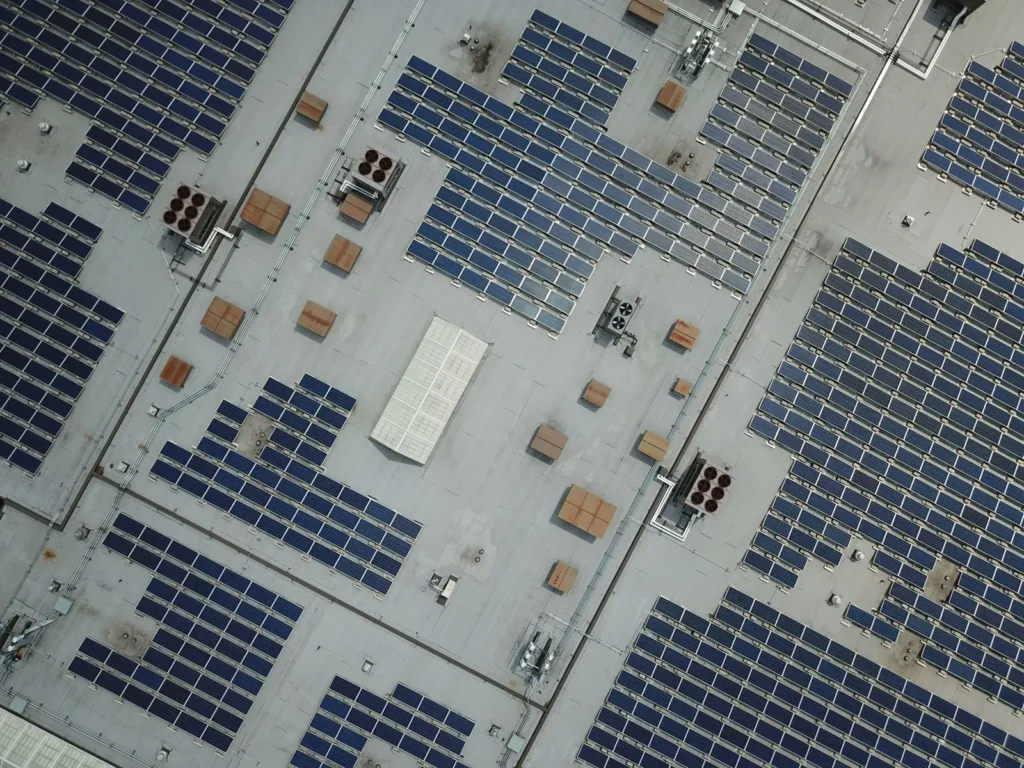 Vista aérea de paneles solares instalados sobre el techo de lámina de una nave industrial